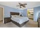 This bedroom features light blue walls, ceiling fan, and a view to the ensuite bathroom at 5325 Bradbury Ct, Tampa, FL 33624