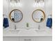 Modern bathroom with double vanity, round mirrors and marble countertops at 4586 Hickory Oak Dr, Brooksville, FL 34601
