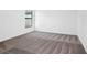 Bright bedroom with grey carpet and large window at 15108 Chimney Swift Rd, Weeki Wachee, FL 34614