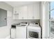 Bright laundry room with washer, dryer, and ample cabinet space at 339 55Th Ave, St Pete Beach, FL 33706