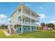 Two-story house with light teal exterior, balconies, and a grassy yard at 339 55Th Ave, St Pete Beach, FL 33706