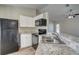Modern kitchen features white cabinets, black appliances, and granite countertops at 3776 Junction St, North Port, FL 34288