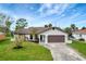 Newly renovated home with a landscaped lawn and attached garage at 4501 Harrington St, Port Charlotte, FL 33948
