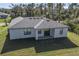 Aerial view of a single-story home with a gray roof, lawn, and sliding glass doors to the patio at 5321 Crestline Ter, Port Charlotte, FL 33981