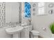 Stylish half bathroom with decorative mirror, vanity, blue decorative art, and window shutters at 8414 Dunham Station Dr, Tampa, FL 33647