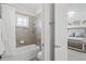 Bright bathroom features a shower-tub combination with tiled walls and a window for natural light at 8414 Dunham Station Dr, Tampa, FL 33647