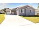 Newly constructed home with gray siding, two-car garage, and a paved driveway at 8448 Red Roe Dr, New Port Richey, FL 34653