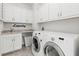 Bright laundry room with white cabinets, granite countertops, and washer/dryer at 8414 Dunham Station Dr, Tampa, FL 33647