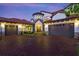 Two-story house with a brick driveway and three-car garage at dusk at 8414 Dunham Station Dr, Tampa, FL 33647