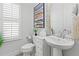 Stylish powder room with pedestal sink and white toilet at 8414 Dunham Station Dr, Tampa, FL 33647