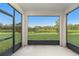Screened porch overlooking a tranquil lake and green landscape at 7779 Yale Harbor Dr, Wesley Chapel, FL 33545