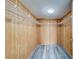 Large walk-in closet with wood shelving and gray laminate flooring at 2699 Seville Blvd # 303, Clearwater, FL 33764