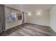 Bright living room with wood-look floors and sliding glass doors leading to a balcony at 2699 Seville Blvd # 303, Clearwater, FL 33764