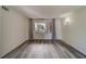 Bright bedroom featuring wood-look floors and large window with curtains at 2699 Seville Blvd # 303, Clearwater, FL 33764