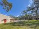 Community pool with lounge chairs and lush green space at 2699 Seville Blvd # 303, Clearwater, FL 33764