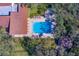 Aerial view of community pool, clubhouse, and surrounding trees at 2699 Seville Blvd # 303, Clearwater, FL 33764