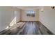 Sunlit bedroom featuring wood-look floors and a large window at 2699 Seville Blvd # 303, Clearwater, FL 33764