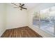 Spacious bedroom with large window, ceiling fan, and wood-look flooring at 3455 Countryside Blvd # 52, Clearwater, FL 33761