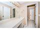 Clean and well-lit bathroom with a large mirror, vanity, and adjacent toilet room for added convenience at 4399 Brooker Creek Dr, Palm Harbor, FL 34685