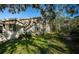 Charming single-story home featuring lush green lawn and mature trees, providing a serene and private outdoor space at 4399 Brooker Creek Dr, Palm Harbor, FL 34685