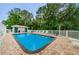 Community pool area features ample seating, a restroom, and a fenced enclosure surrounded by mature trees at 4399 Brooker Creek Dr, Palm Harbor, FL 34685