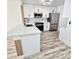 Modern white kitchen with stainless steel appliances and island at 12200 Vonn Rd # 2106, Largo, FL 33774