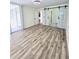 Open living room with wood-look floors and barn doors leading to bathroom at 12200 Vonn Rd # 2106, Largo, FL 33774