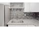 Modern kitchen sink with granite countertop and grey backsplash at 4204 N Marguerite St, Tampa, FL 33603