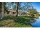 Landscaped backyard with canal view and patio access at 4399 Brooker Creek Dr, Palm Harbor, FL 34685