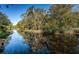 Tranquil canal reflecting the surrounding trees and sky at 4399 Brooker Creek Dr, Palm Harbor, FL 34685