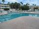Community pool with brick patio and surrounding palm trees at 6575 99Th N Way # 22201, St Petersburg, FL 33708