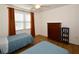 Well-lit bedroom with twin beds, dresser, and window coverings at 6575 99Th N Way # 22201, St Petersburg, FL 33708