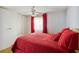 Bright bedroom with red bedding and ceiling fan at 5319 Montego Dr, Zephyrhills, FL 33541