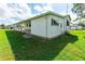 Side view of a mobile home with covered porch and green grass at 5319 Montego Dr, Zephyrhills, FL 33541