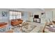 Bright living room featuring neutral tile flooring, stylish furnishings, and ample natural light at 10801 Fillmore Ave, Port Richey, FL 34668