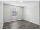 Simple bedroom with dark gray vinyl flooring and a window with blinds at 3121 Briar St, Wesley Chapel, FL 33543