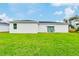 Large grassy backyard with patio and sliding glass doors at 5221 Chaney Ter, Port Charlotte, FL 33981