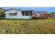 Exterior view of home with a grassy yard, deck, and screened-in porch at 5346 Quist Dr, Port Richey, FL 34668
