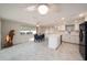 Modern kitchen with white cabinetry, quartz countertops, and stainless steel appliances, open to dining area at 5346 Quist Dr, Port Richey, FL 34668