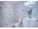 Updated bathroom with marble-look tile and white vanity at 701 Mirror Lake N Dr # 309, St Petersburg, FL 33701