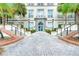 Grand building entrance with brick walkway, stairs, and lush landscaping at 701 Mirror Lake N Dr # 309, St Petersburg, FL 33701