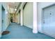 Building hallway with teal carpet, white columns, and light fixtures at 701 Mirror Lake N Dr # 309, St Petersburg, FL 33701