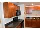 Modern kitchen with wood cabinets and black appliances at 11003 N 27Th St, Tampa, FL 33612