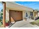Brown garage door with a white door and decorative columns at 10801 Fillmore Ave, Port Richey, FL 34668