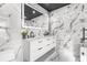 Modern bathroom with double vanity, marble tile, and LED mirror at 120 Brightwater Dr # 2, Clearwater Beach, FL 33767
