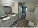 Double vanity bathroom with updated flooring and access to bedroom at 12730 Mangrove Forest Dr, Riverview, FL 33579