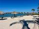 Beautiful beach with white sand, blue water, and tiki huts; perfect for relaxing and enjoying the waterfront view at 6061 Bahia Del Mar Cir # 241, St Petersburg, FL 33715