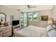 Bright bedroom with ceiling fan, water view, and access to the balcony at 6061 Bahia Del Mar Cir # 241, St Petersburg, FL 33715