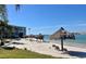 Stunning waterfront beach area featuring tiki umbrellas and lounge chairs, perfect for relaxing by the tranquil water at 6061 Bahia Del Mar Cir # 241, St Petersburg, FL 33715