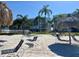Picturesque beach area with lounge chairs and tiki umbrellas, complemented by lush palm trees and waterfront condos at 6061 Bahia Del Mar Cir # 241, St Petersburg, FL 33715